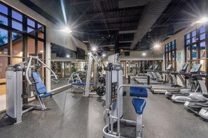 Ein Fitnessstudio mit verschiedenen Trainingsgeräten, darunter Laufbänder und Kraftgeräte.