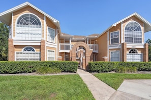 A two-story house with a central entrance, a covered porch, and a visible garage number. - Inviting 3 BR Condo in Kissimmee City, 6703 (Orlando)
