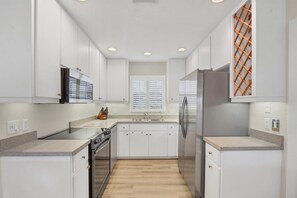 Fully-equipped kitchen overlooking the dining room and living room. Dining table seats 4 with an additional 4 at the kitchen island - Stunning 2 BR House in Englewood City, 5928 (Charlotte County)