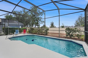 An indoor swimming pool with a clear view of the sky, surrounded by a metal frame structure. - Spacious Family Home in Kissimmee, 6691 (Orlando)
