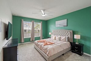 A bedroom with a bed, nightstands, a ceiling fan, a window with curtains, and a painting on the wall. - Grand Mansion in Davenport City, 6696 (Orlando)