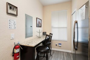 A kitchen with a stainless steel refrigerator, a countertop with a sink, and a fire extinguisher. - Elegant 4 Bedroom Townhome in Davenport, 6694 (Orlando)
