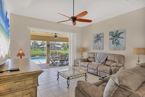Living room overlooking pool. Living room features plenty of comfy seating and 75-inch Smart TV - Modern 3 Bed House in Rotonda West, 5939 (Charlotte County)