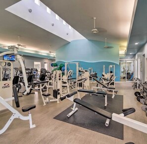A gym with various exercise equipment, a television, and a ceiling fan. - Cozy Condo with Balcony in Punta Gorda, 6339 (Florida)