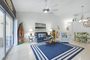 Large living space includes patio access overlooking the pond, and 75-inch Smart TV - Cozy Condo with Balcony in Punta Gorda, 6339 (Florida)