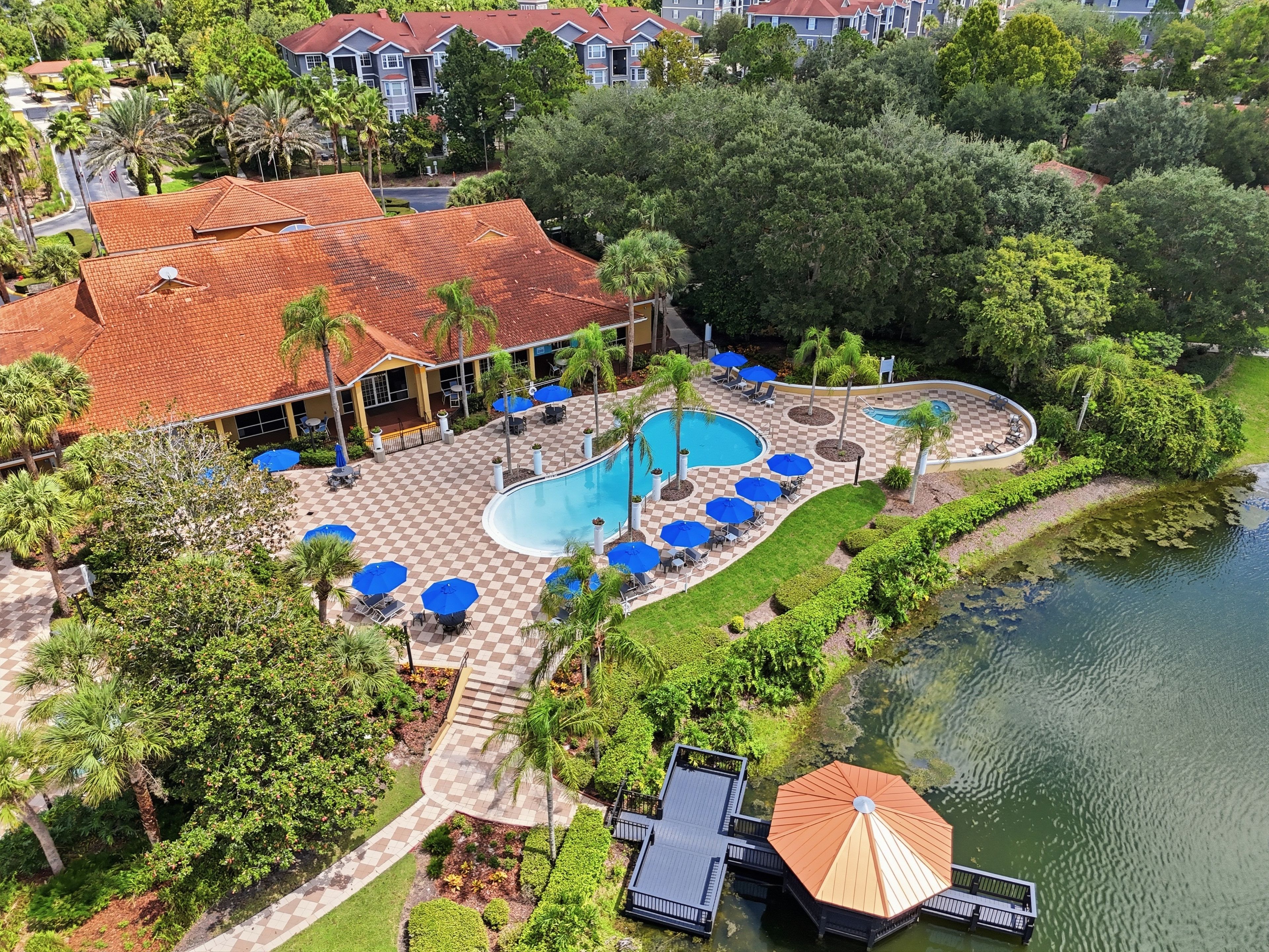 Un complexe hôtelier doté d’une piscine, de chaises longues et d’un quai.