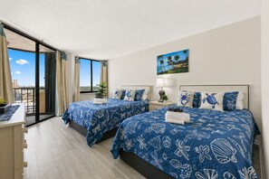 A hotel room with two beds, a balcony, and a painting of a beach scene. - Oceanfront Maisons Sur Mer | Amazing Ocean Views (Myrtle Beach)