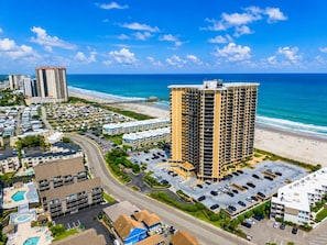 A coastal hotel with multiple floors, a parking lot, and a beach view. - Oceanfront Maisons Sur Mer | Amazing Ocean Views (Myrtle Beach)