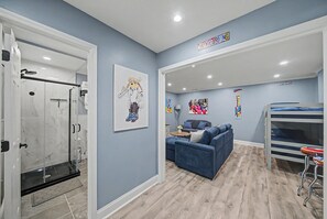 A modern interior with a shower, a sofa, and a bunk bed. - Mountain Creek Ski Condo | 3BR, Arcade, Mtn Views (Vernon Township)