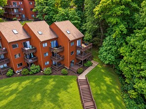 A multi-story wooden building with balconies, surrounded by lush greenery. - Mountain Creek Ski Condo | 3BR, Arcade, Mtn Views (Vernon Township)