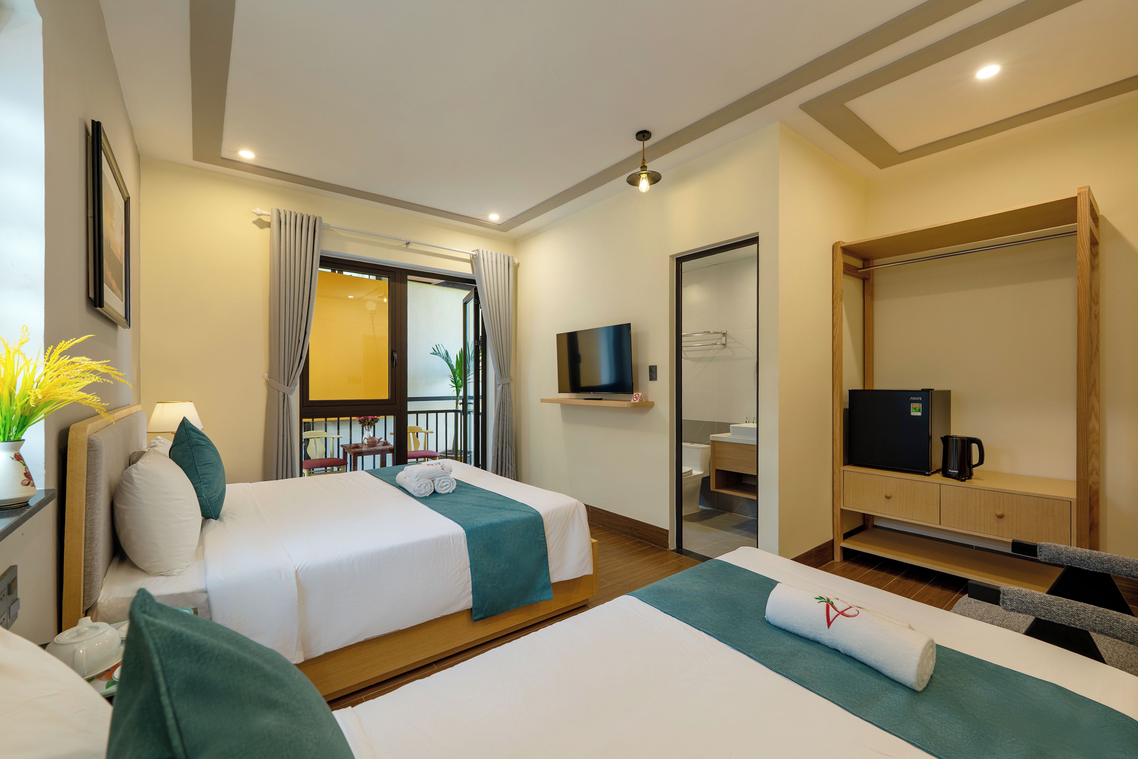 Une chambre d’hôtel avec deux lits, une télévision, un minibar et un balcon avec vue.