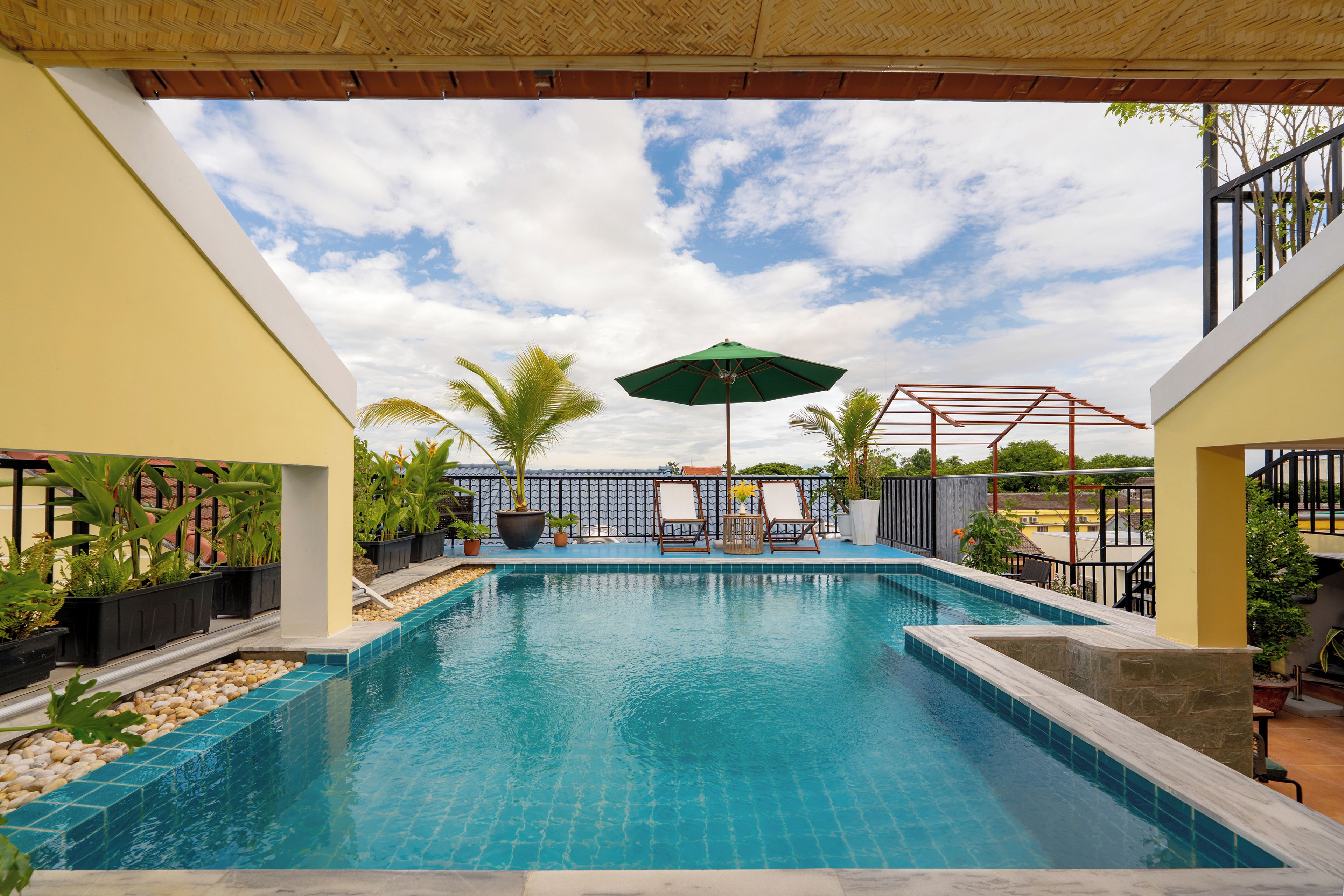 A swimming pool with a view of the sky and palm trees.