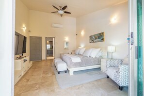 A bedroom with a bed, bedside tables, a chair, a ceiling fan, and a painting on the wall. - A 100% Private Home for Family and Friends (San José del Cabo)