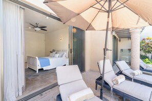 A hotel room with a balcony, a bed, a ceiling fan, and a large umbrella. - A 100% Private Home for Family and Friends (San José del Cabo)