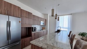 A modern kitchen with a central island, stainless steel appliances, and wooden cabinetry. - Spacious 3-bedroom Penthouse,with a beautiful view in fabulous San José del Cabo (San José del Cabo)