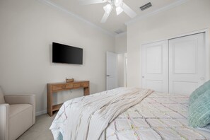 A bedroom with a bed, a television, a desk, and a chair. - Relaxing pool home at Sarasota National Peace In The Palms (Venice)