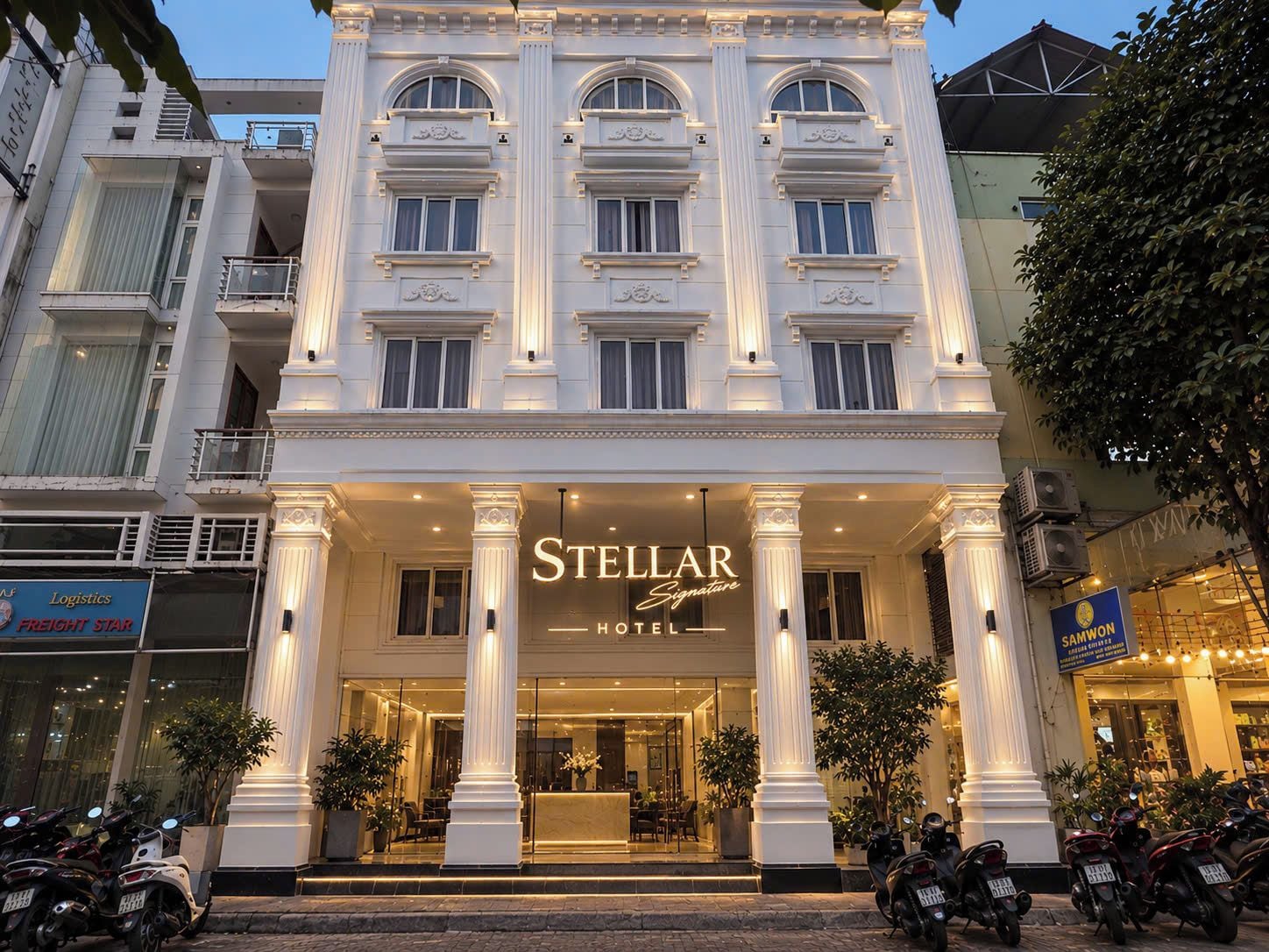 A hotel with a grand entrance, multiple floors, and a well-lit facade.