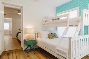 Habitación con literas, mesita de noche y pared con diseño.
