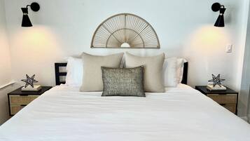 Un lit bien fait, avec une tête de lit, deux tables de chevet dotées de lampes et des objets décoratifs en forme d’étoile posés sur les tables de chevet.