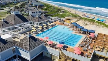 A resort with a large swimming pool, beach access, and multiple buildings with distinct architectural styles.