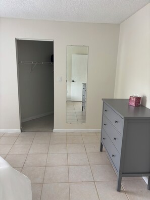Une chambre à coucher avec un placard, une commode et un miroir.