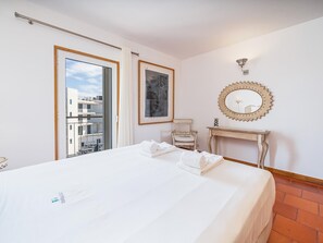 A hotel room with a bed, a small table, a mirror, and a framed picture on the wall. - Top Floor Apartment, Marina View, Lagos (Lagos)
