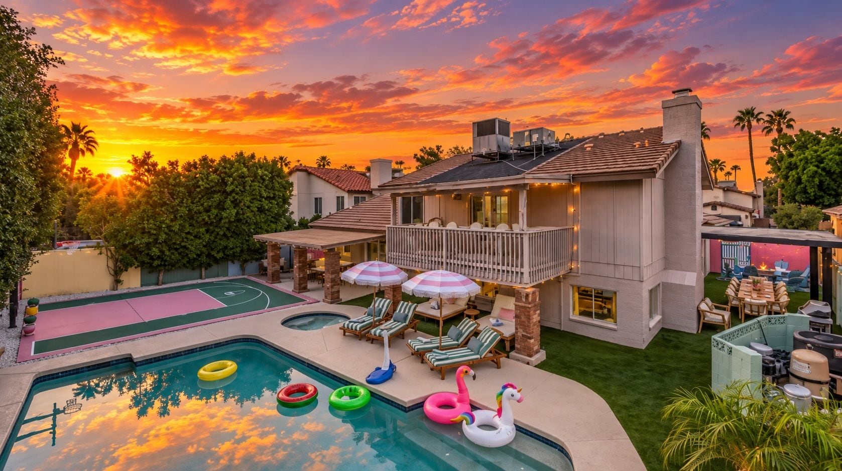 Propiedad residencial con piscina, mobiliario exterior y vista al atardecer.