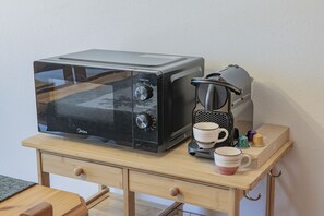 A microwave and coffee maker on a wooden table with a drawer underneath. - La Casa di Bud - AffittiPontediLegno (Temù)