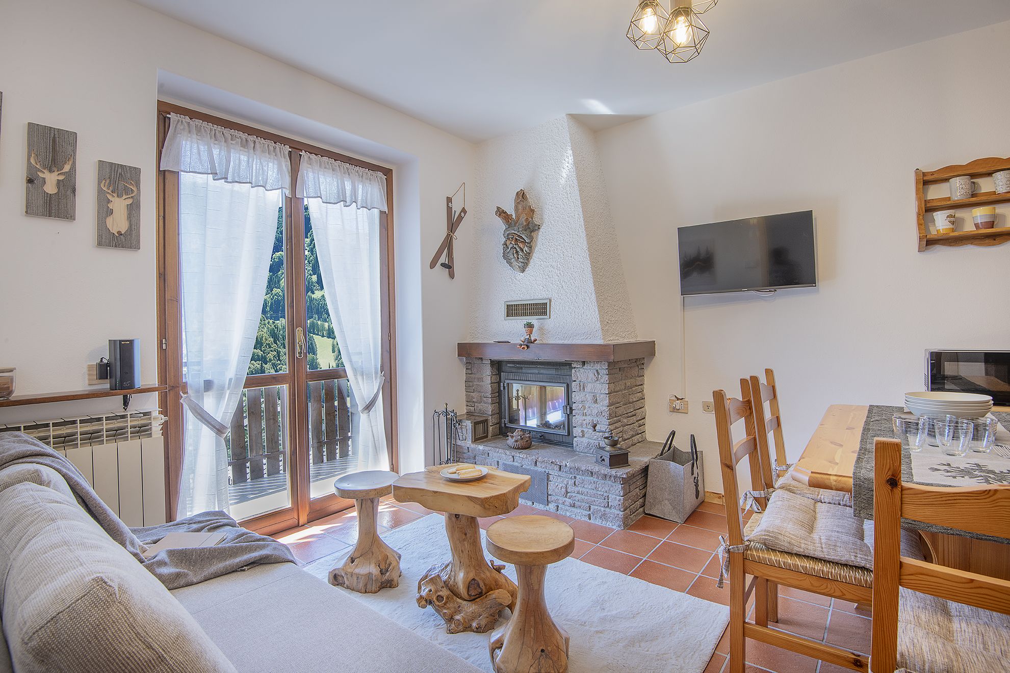 A living room with a fireplace, a television, and a dining area with a table and chairs.