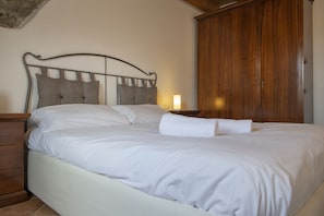 A neatly made bed with white linens and a wooden headboard. - AffittiPontediLegno - Sguardo sulle cime (Ponte di legno)