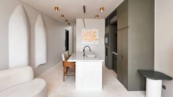 A modern kitchen with a central island, built-in appliances, and pendant lighting.