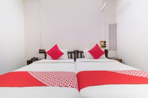 A double bed with two pillows, a bedside table with a telephone, and a wall socket. - Hotel O Bhuikot Fort Solapur (Solapur)