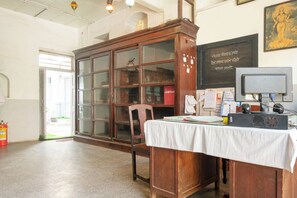 A room with a wooden cabinet, a desk with papers, a computer, and a fire extinguisher. - Hotel O Bhuikot Fort Solapur (Solapur)