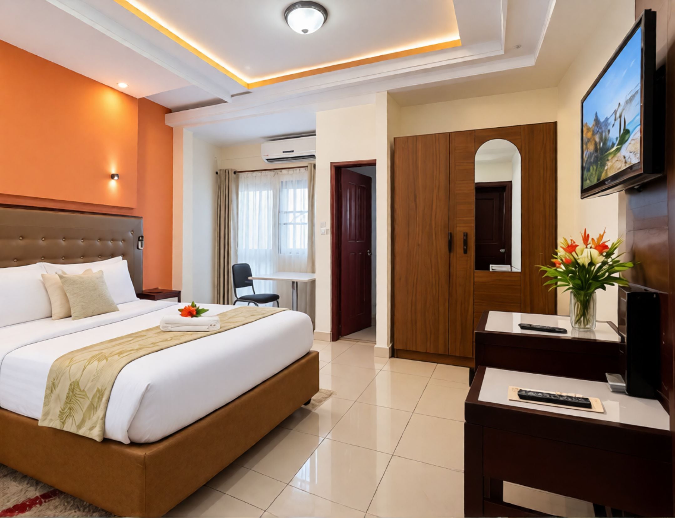 Une chambre d’hôtel avec un grand lit, un bureau, une télévision et une armoire.