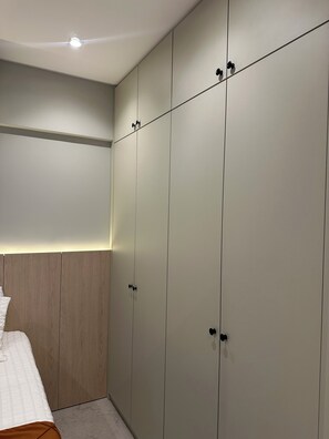 Ein Schlafzimmer mit einem Bett, einem Kleiderschrank und einer Deckenleuchte.