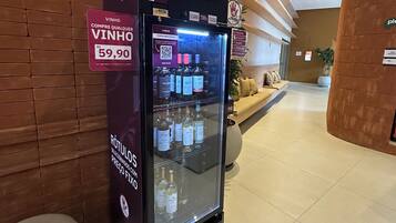 A vending machine with a sign indicating a price of 59.90, located in a lobby with a brick wall and a seating area in the background.