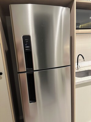 Ein Edelstahl-Kühlschrank mit digitaler Steuerung, einem integrierten Gefrierfach und einem Wasserspender für Eiswürfel.