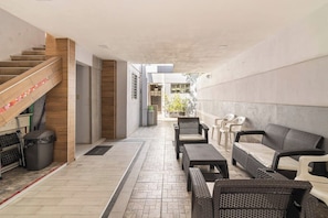 A modern interior with a staircase, seating area, and a view of the outside.