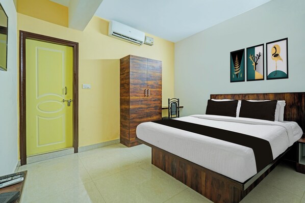 A hotel room with a bed, a wardrobe, a door, and a wall-mounted air conditioner. - Collection O Virajpete Bus Terminal (Virajpet)