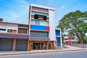 A multi-story building with a storefront on the ground floor. - Collection O Virajpete Bus Terminal (Virajpet)