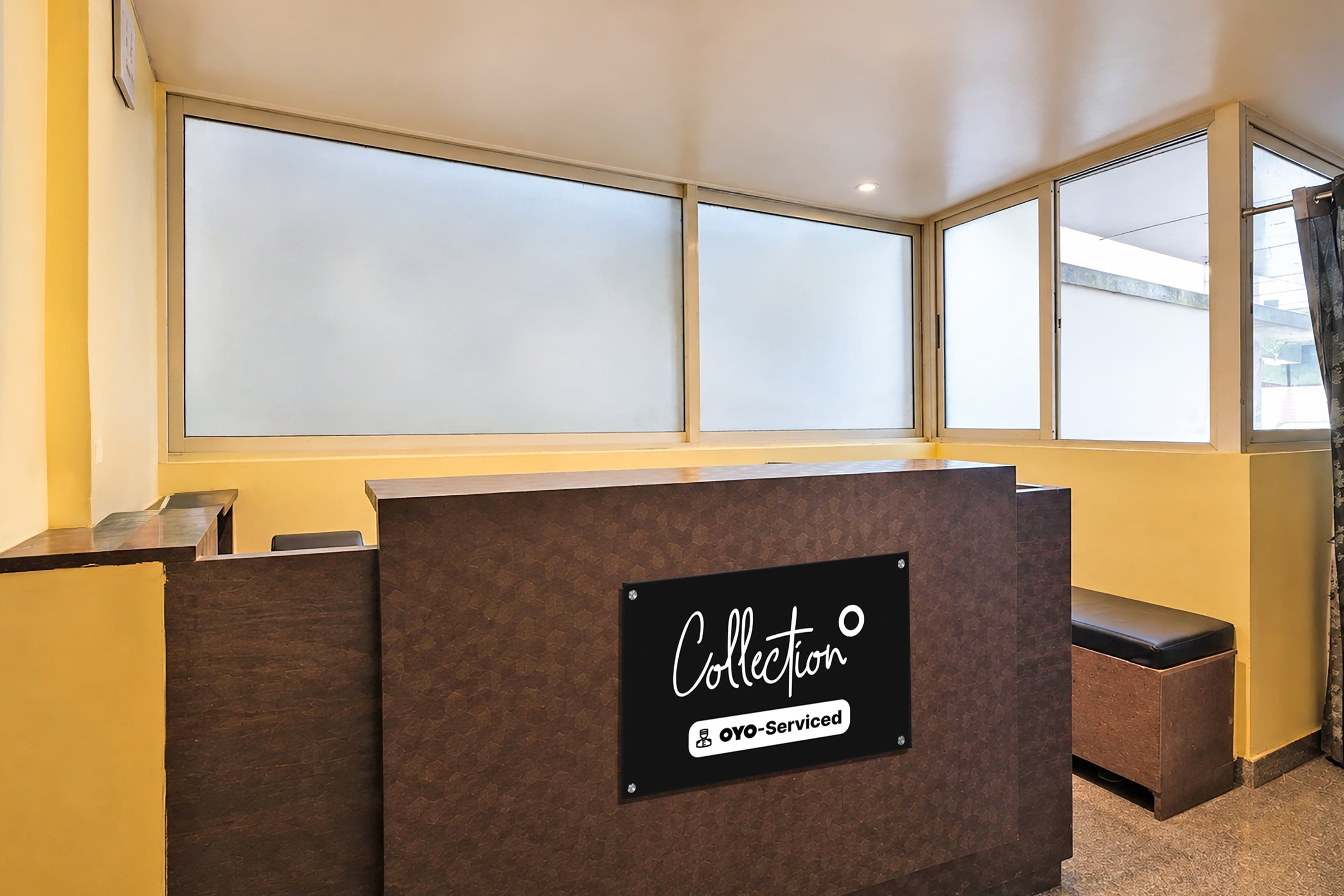 A reception desk with a 'Collection' sign, large windows, and a view of the outside.