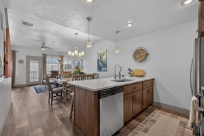 A modern kitchen with a central island, wooden cabinets, and a dishwasher. - The Payette Perch- Pets ok- sleeps 6 (McCall)