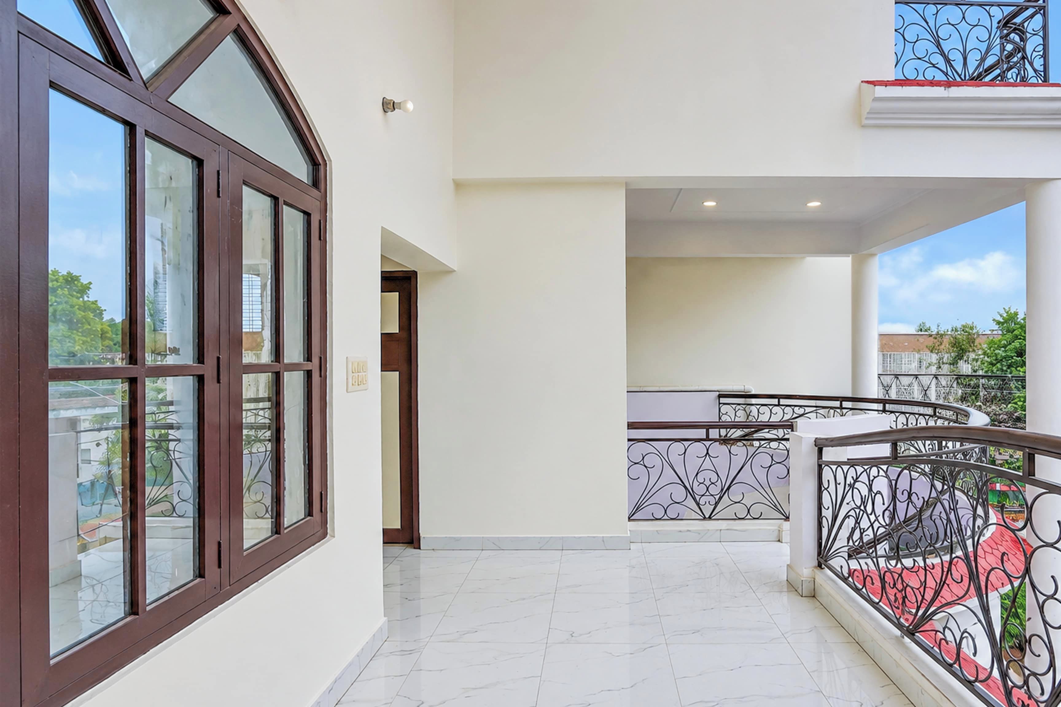 A modern residential building with a balcony, a staircase, and a view of the surrounding area.