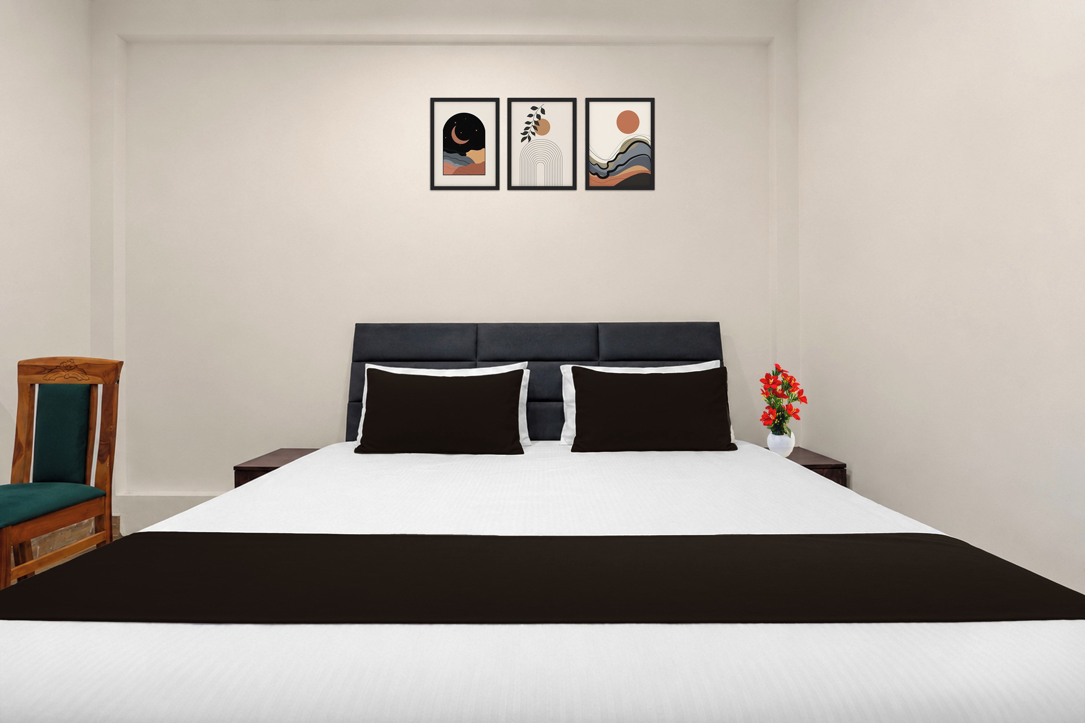 Un dormitorio con una cama, una mesita de noche, una silla y tres cuadros en la pared.
