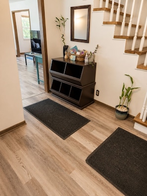 Un interior modern amb una escala de fusta, un moble negre per a l'entreteniment i una planta en test.