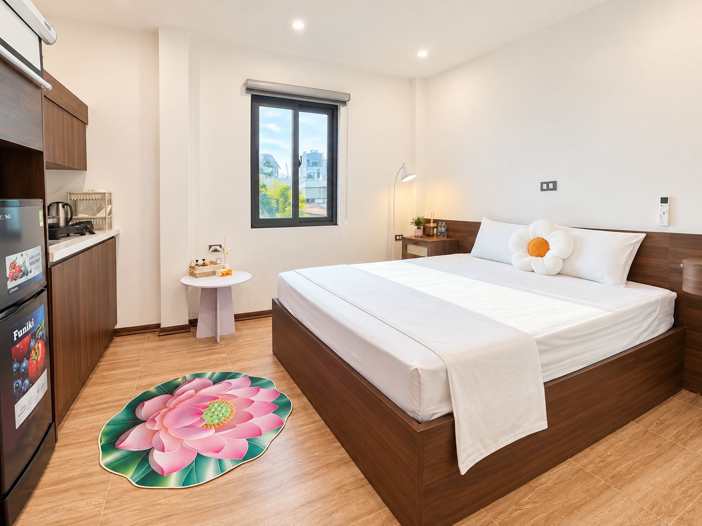 Ein Hotelzimmer mit einem Bett, einem kleinen Tisch, einem Kühlschrank, einem Fenster und einem Badezimmer.