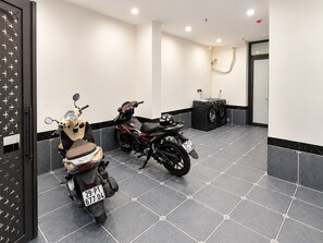 Un baño moderno y limpio con dos motocicletas estacionadas, una lavadora y piso de baldosas.
