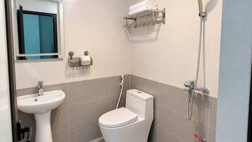 Un baño con inodoro, lavamanos y ducha.