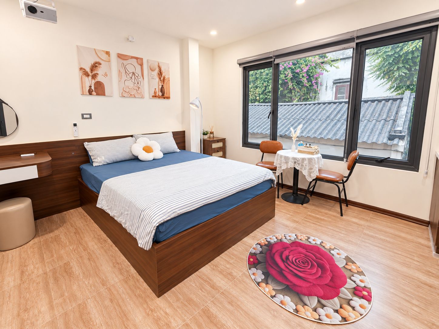 Un dormitorio con cama, mesita de noche, silla y ventana con vistas al exterior.