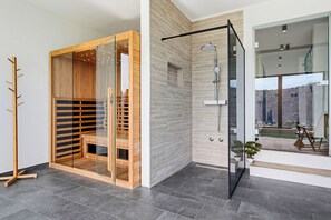 A modern bathroom with a glass shower enclosure, a wooden sauna, and a view of the outdoors. - Forest Peak Retreat with Indoor Pool and Sauna, Ravna Gora, Croatia (Ravna Gora)